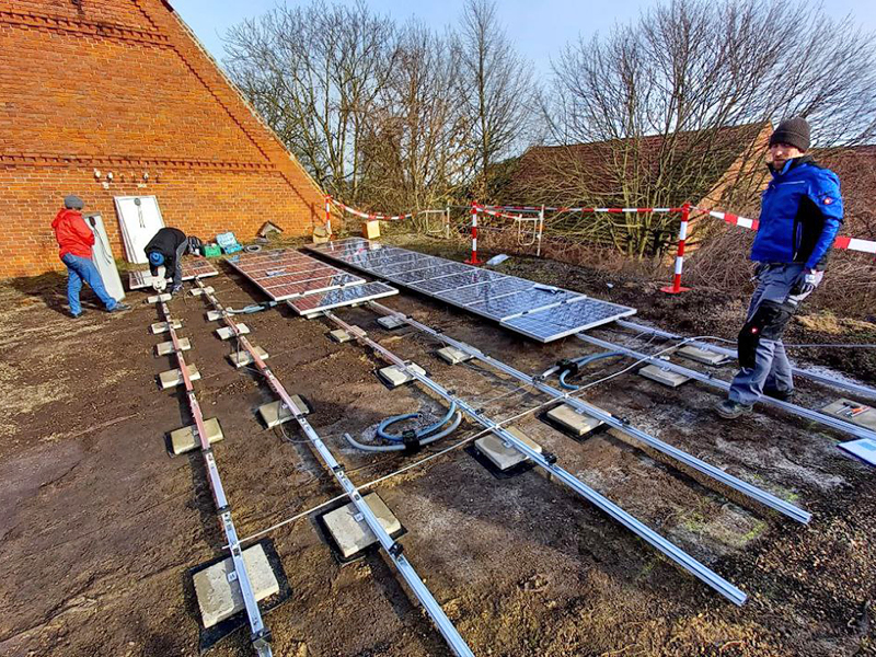 Foto von Bewohnern aus Stedorf, die Solarzellen am Dach anbringen.
